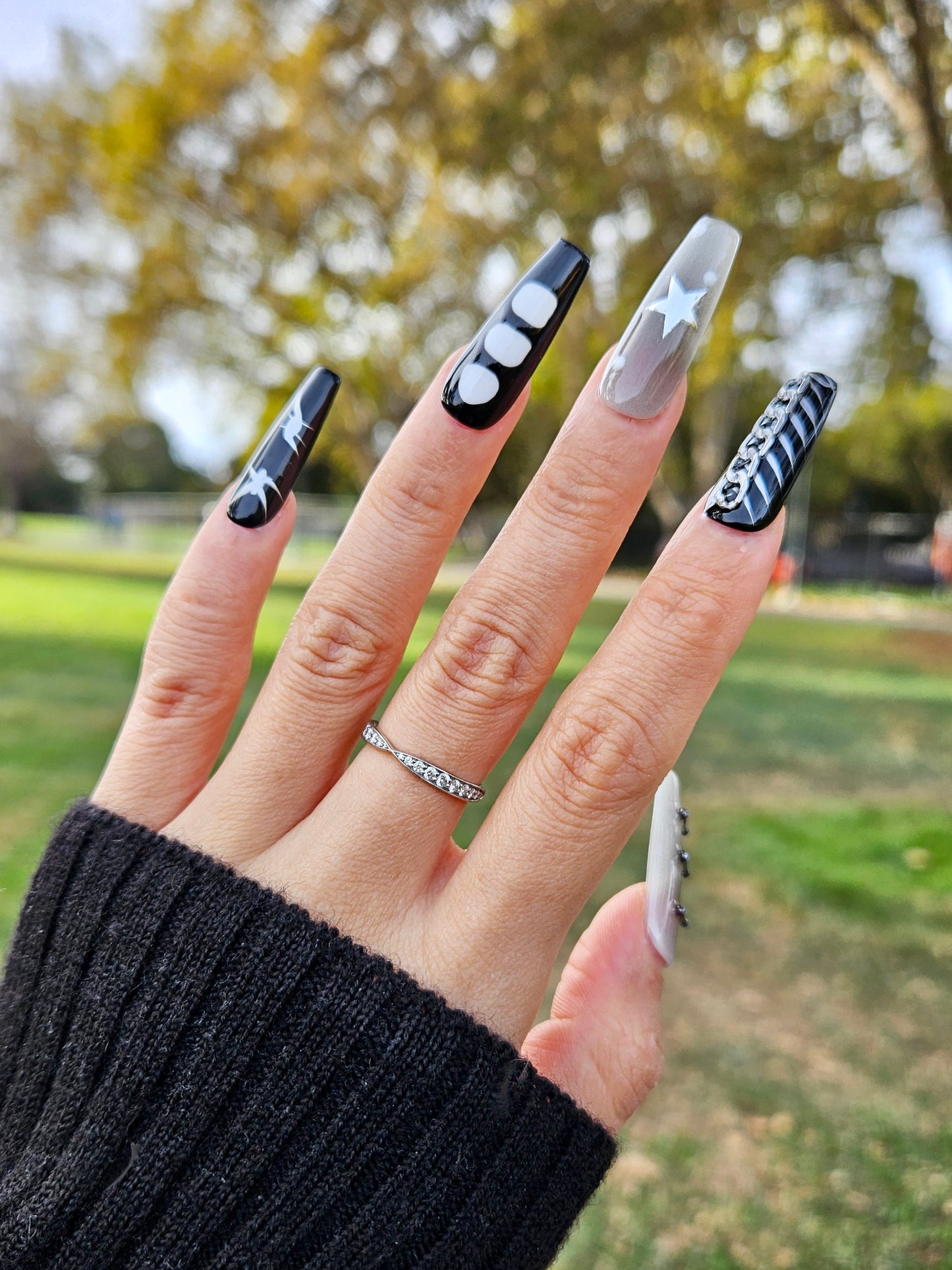 Starlit Noir Press On Nails, featuring a striking blend of black, white, and metallic accents