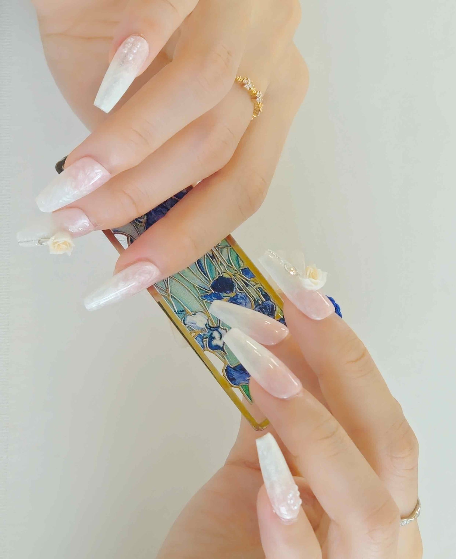 Girl's hands with white and pink shiny press-on nails from Yitaya