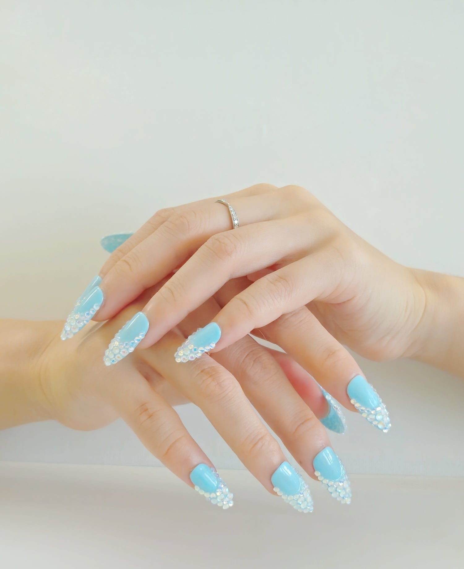 Girl hands with beautiful blue press-on nails decorated with glasses from Yitaya