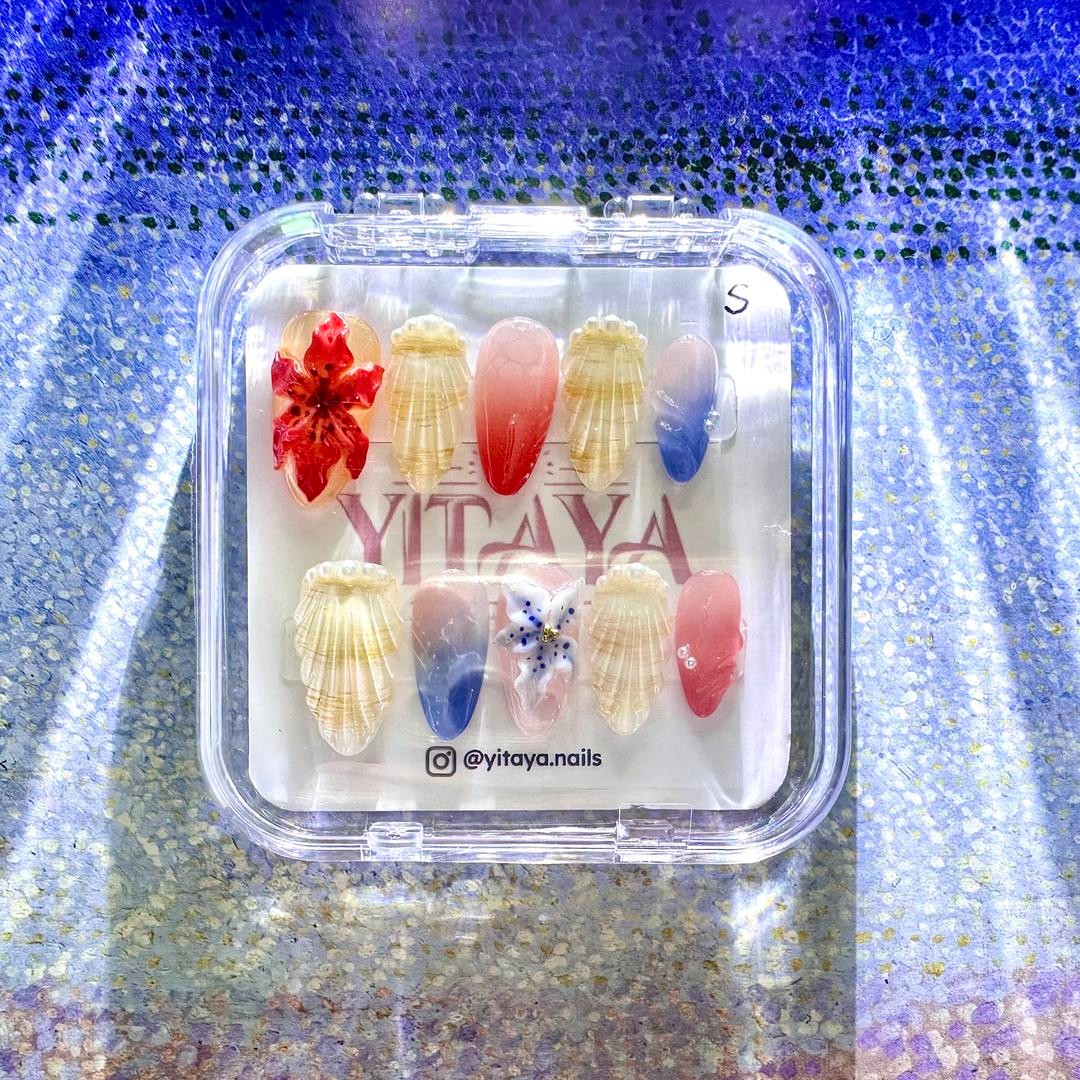 3D Coastal Bliss Press On Nails, feature exquisite shell details, soft ombré blues, corals, and delicate floral accents