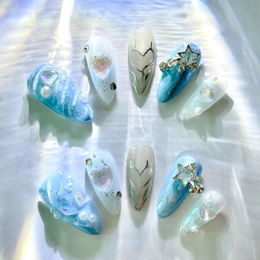  3D Ocean Breeze Artistic Press On Nails from Yitaya -- shimmering blue base adorned with snowflakes, stars, and pearls