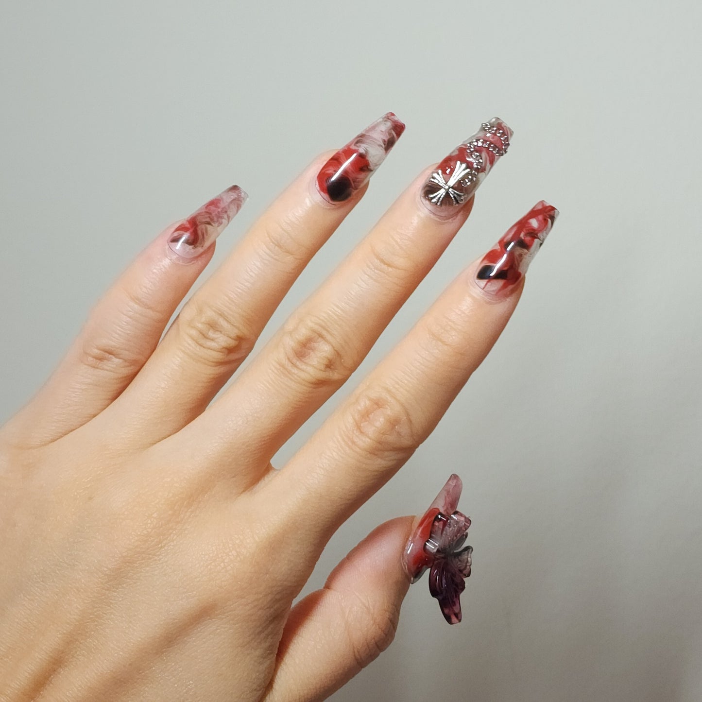 Crucipapillon Press On Nails from Yitaya, featuring a striking marbled pattern in shades of red, black, and white, creating a dynamic and eye-catching effect