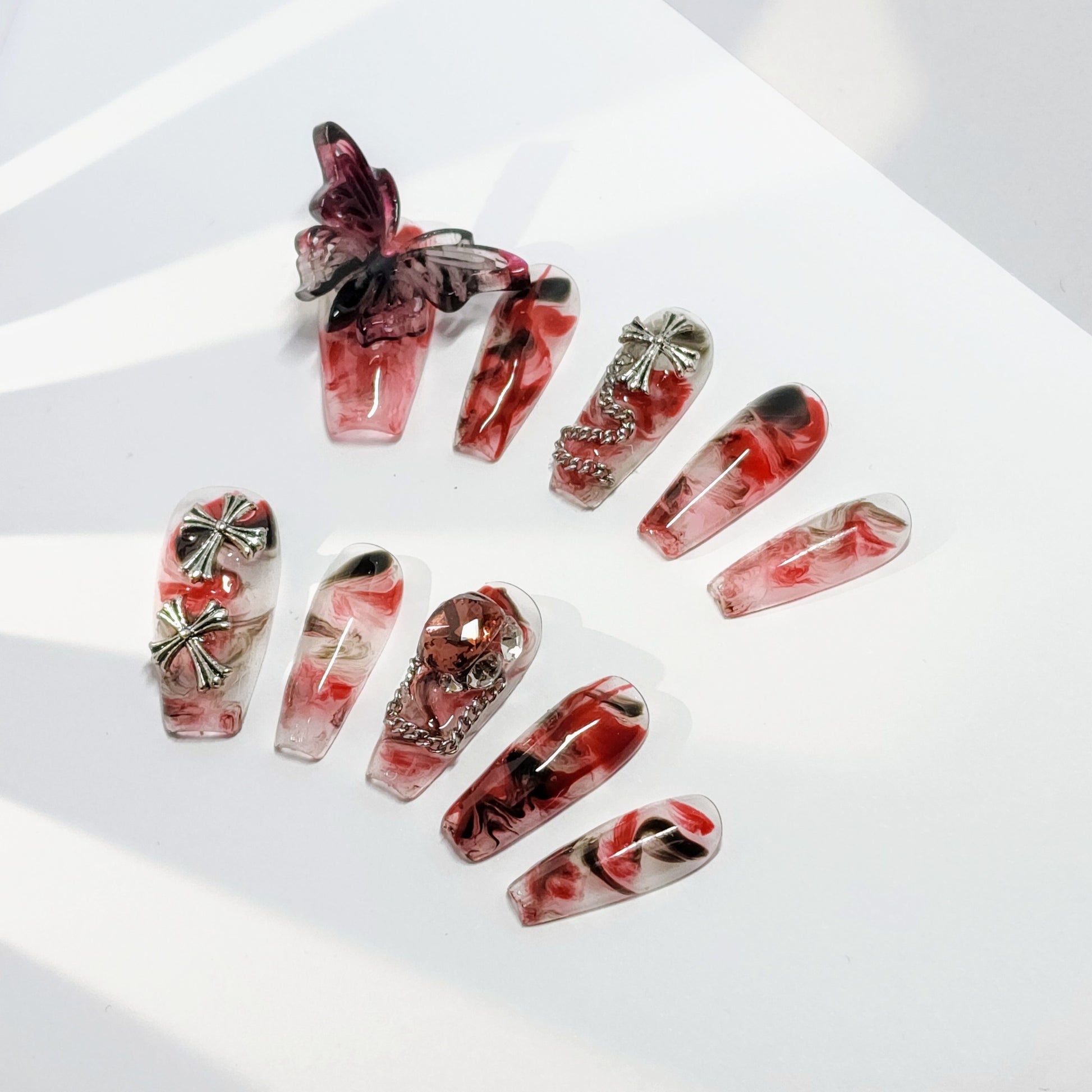 Crucipapillon Press On Nails from Yitaya, featuring a striking marbled pattern in shades of red, black, and white, creating a dynamic and eye-catching effect