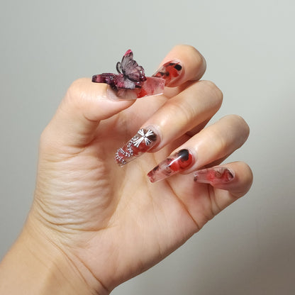 Crucipapillon Press On Nails from Yitaya, featuring a striking marbled pattern in shades of red, black, and white, creating a dynamic and eye-catching effect