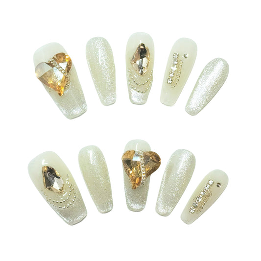 Glitz Heart press-on nails from Yitaya, featuring a shimmering white base with gold accents and dazzling rhinestones