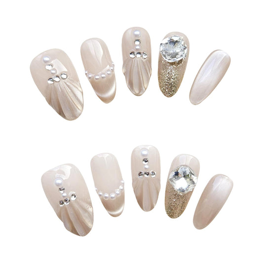 Luxe Pearl Glam short almond press on nails -- Nude base with pearl, rhinestone, and gold glitter accents.