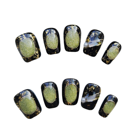 Mystic Nightfall Coffin Press On Nails, featuring a dramatic black base with shimmering green glitter accents and gold foil splatters