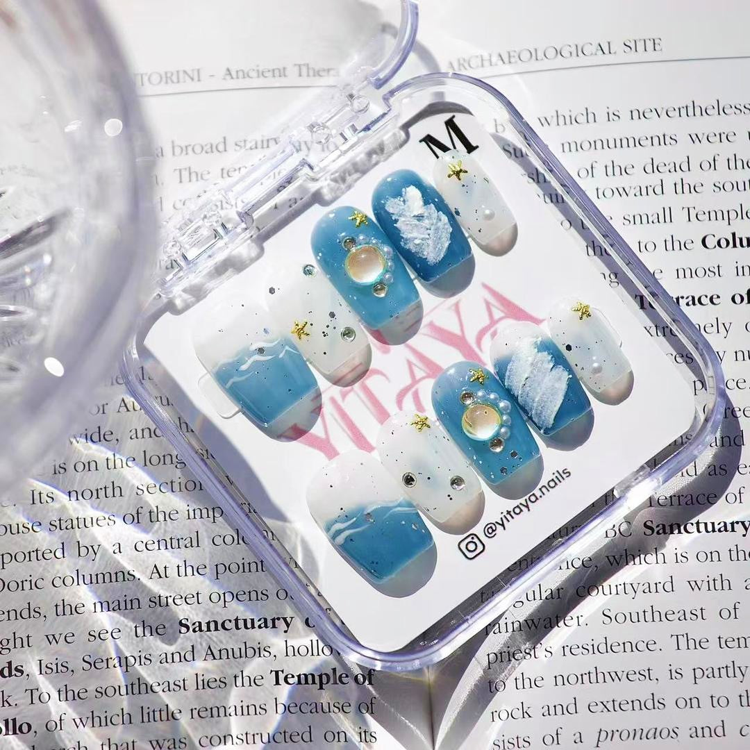 Oceanic Glow Press On Nails, featuring deep blue ocean hues, whimsical white waves, and sparkling sea-inspired accents