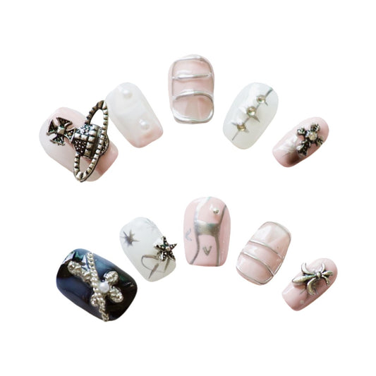 Punk Cosmic Chic Press On Nails, featuring a dreamy palette of pink, black, and white, embellished with intricate metallic charms and punk designs